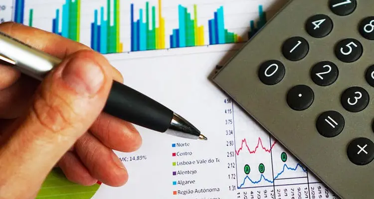 Grafice și calculator pe o masă de lucru, imagine despre estimarea mărimii pieței